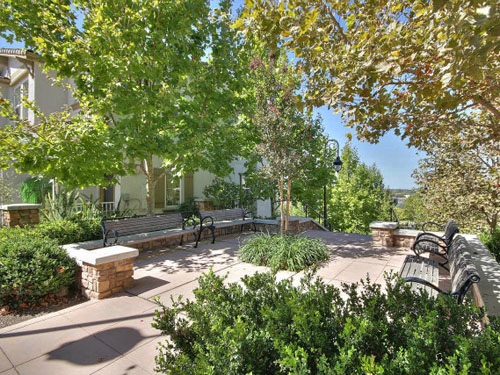 hm-5-website A series of outdoor benches shaded by trees next to homes at the Heritage Master Association.