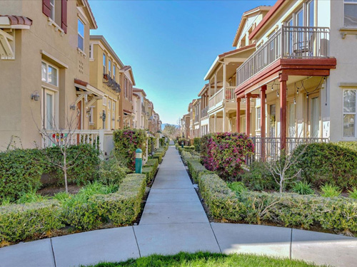 hm-7-website A side walk surrounded by grass and other plants is shown between homes at Heritage Master Association.